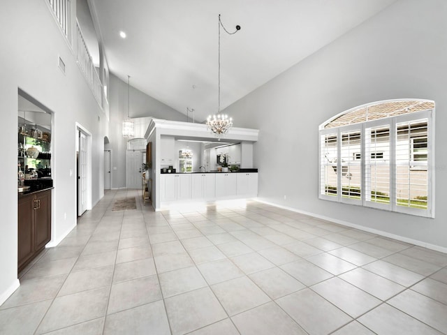 8737 Pebble Creek Ln, Sarasota, FL 34238 - unfurnished living room with high vaulted ceiling, a chandelier, light tile patterned floors, and baseboards