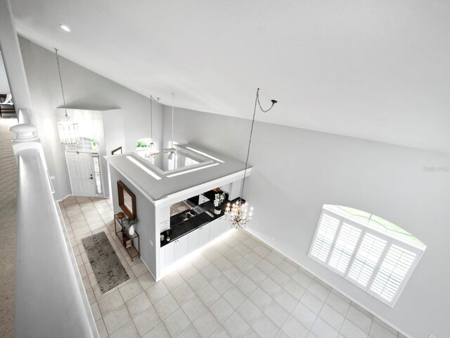 8737 Pebble Creek Ln, Sarasota, FL 34238 - hall with a chandelier, vaulted ceiling, light tile patterned floors, and baseboards