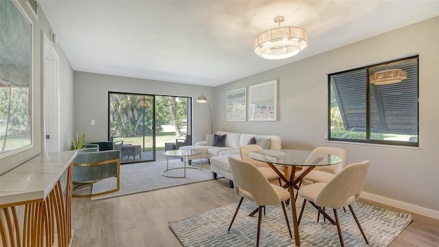 dining space with light hardwood / wood-style floors and an inviting chandelier