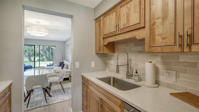 kitchen with backsplash, sink, and light hardwood / wood-style flooring