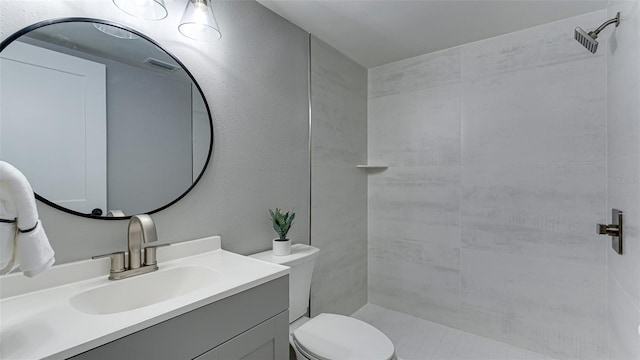 bathroom featuring a shower, vanity, and toilet