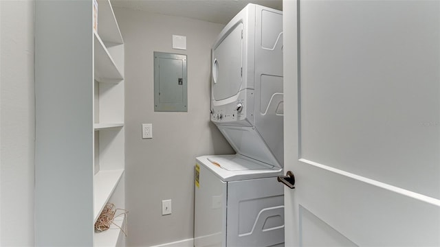 washroom with stacked washing maching and dryer and electric panel