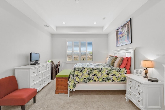 bedroom featuring light carpet and a tray ceiling