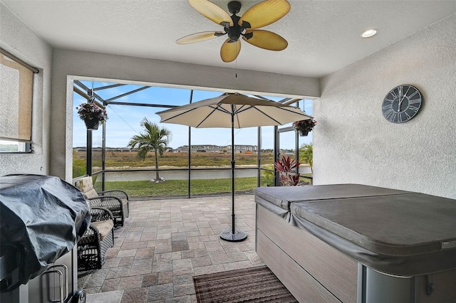 view of patio / terrace with ceiling fan, a lanai, grilling area, and a hot tub