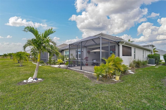 back of house featuring a lanai, central AC, a patio area, and a lawn