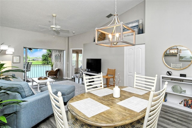 dining space with ceiling fan, lofted ceiling, and dark wood-type flooring