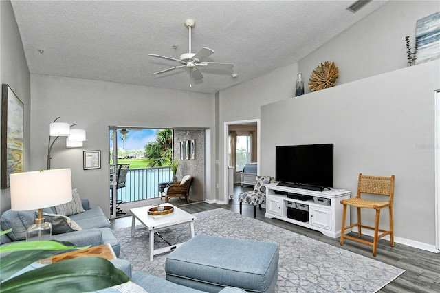 living room with ceiling fan, dark wood-type flooring, and a textured ceiling