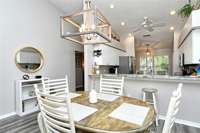 dining room featuring ceiling fan with notable chandelier, a textured ceiling, dark hardwood / wood-style flooring, and sink