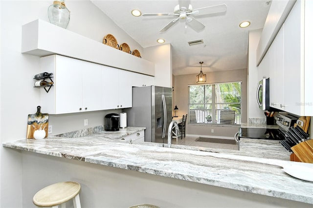 kitchen featuring light stone countertops, kitchen peninsula, decorative light fixtures, white cabinets, and appliances with stainless steel finishes