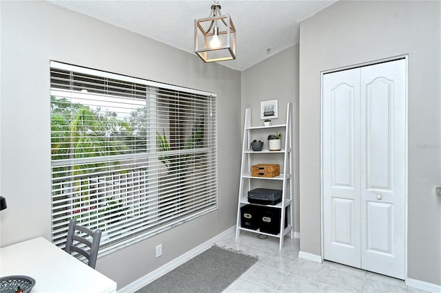 interior space with light tile patterned floors and a textured ceiling