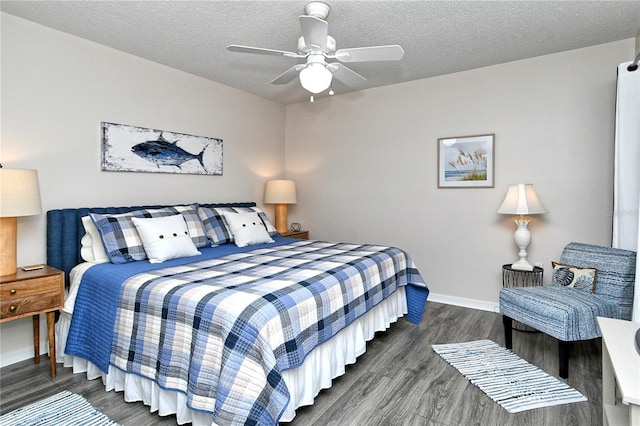 bedroom with a textured ceiling, ceiling fan, and dark wood-type flooring