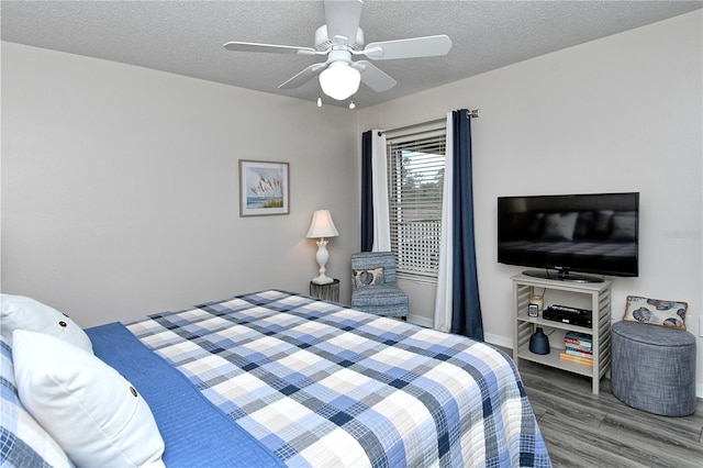 bedroom with a textured ceiling, ceiling fan, and dark wood-type flooring