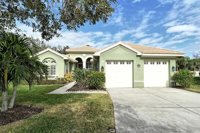 mediterranean / spanish-style home with a garage and a front lawn