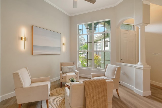 sitting room with ceiling fan, crown molding, ornate columns, and light hardwood / wood-style floors