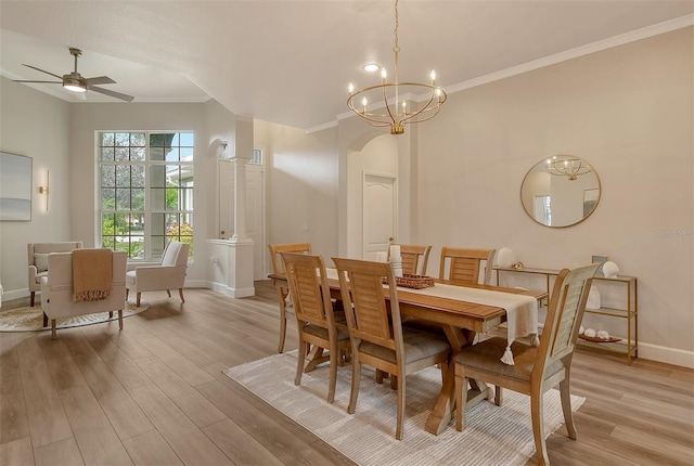 dining area with light wood-type flooring, ornamental molding, and ceiling fan with notable chandelier