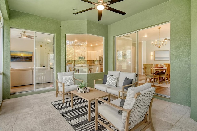 sunroom featuring ceiling fan with notable chandelier