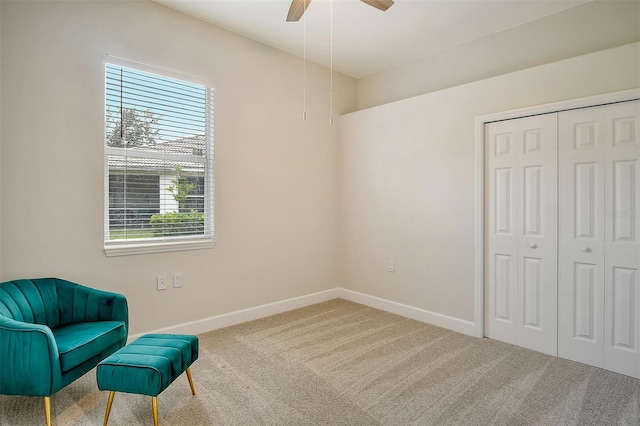 living area featuring carpet floors and ceiling fan