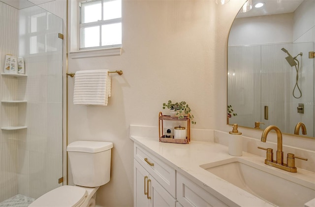 bathroom featuring toilet, a shower with door, and vanity