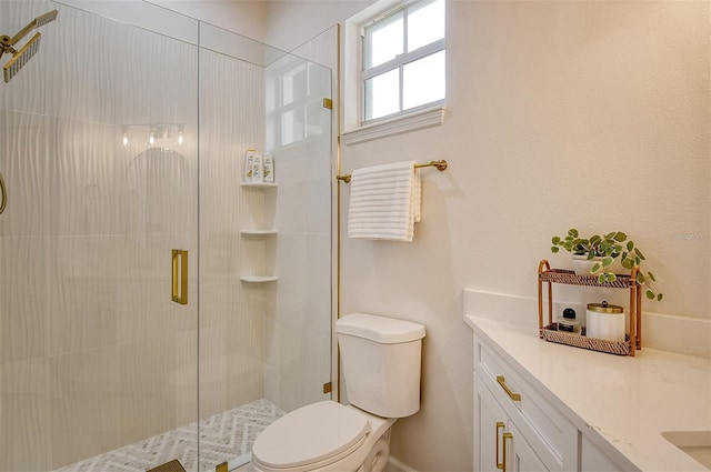 bathroom with a shower with shower door, vanity, and toilet