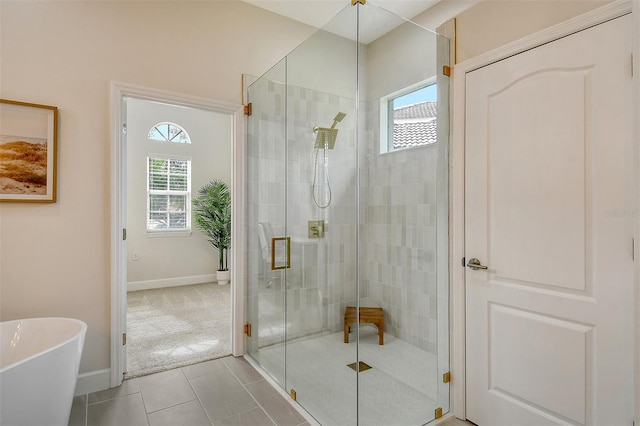 bathroom with tile patterned flooring and separate shower and tub