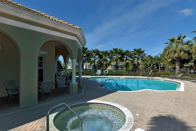 view of pool featuring a hot tub and a patio