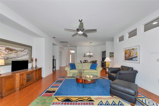 living room featuring ceiling fan with notable chandelier and wood-type flooring