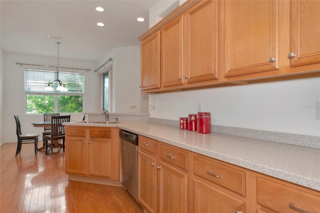 kitchen with light hardwood / wood-style floors, light stone countertops, hanging light fixtures, stainless steel dishwasher, and sink