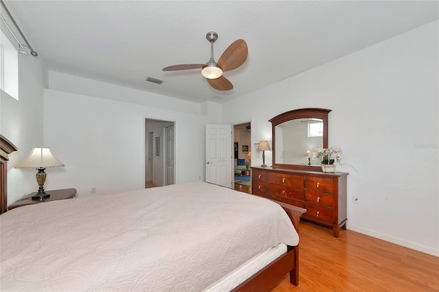 bedroom featuring ceiling fan, multiple windows, and light hardwood / wood-style flooring