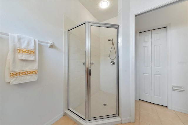 bathroom featuring vaulted ceiling, tile patterned floors, and a shower with door