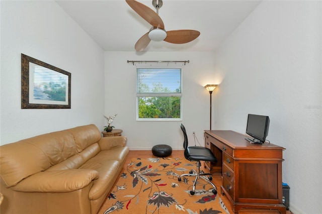 home office with light wood-type flooring and ceiling fan