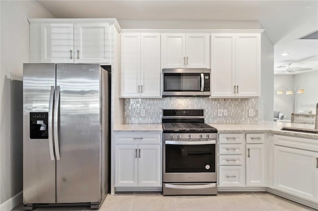 kitchen featuring sink, white cabinets, light tile patterned floors, and appliances with stainless steel finishes