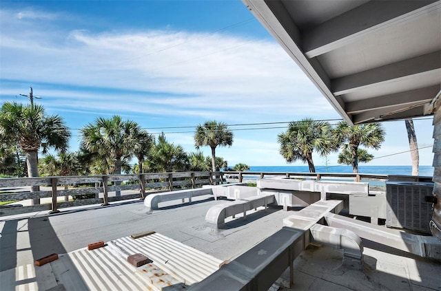 wooden terrace with a water view and central AC unit