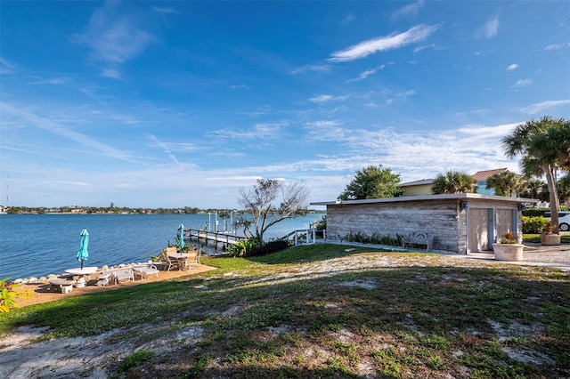 view of dock with a yard and a water view