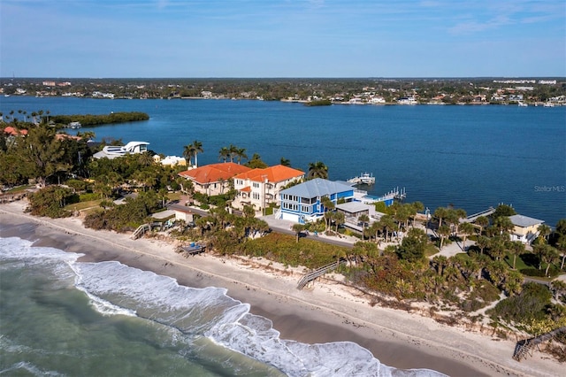 birds eye view of property with a water view and a beach view