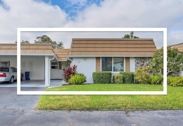 view of front of house featuring a carport and a front lawn