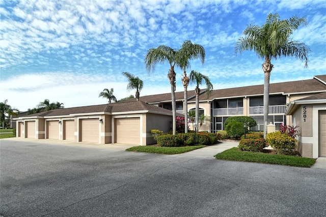 view of front facade featuring stucco siding and community garages