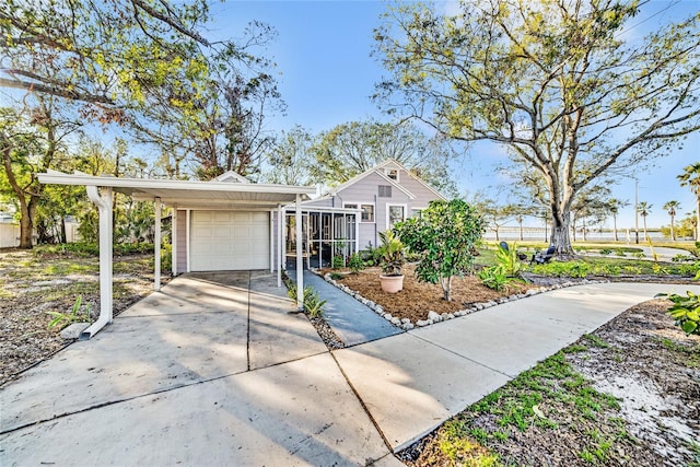 view of front of home with a sunroom, a carport, and a garage