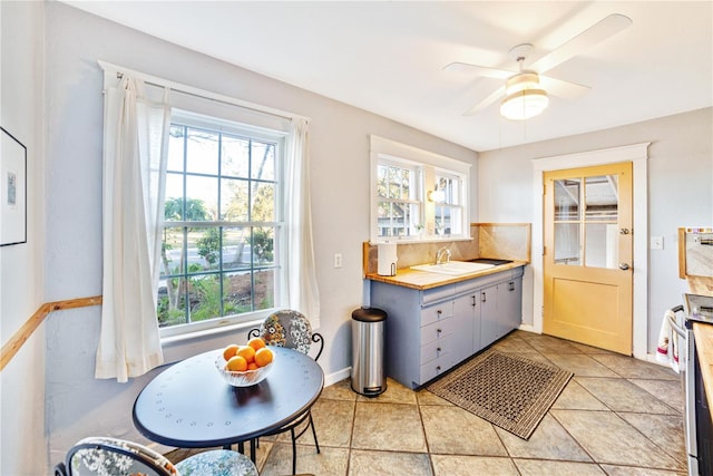 kitchen featuring stainless steel electric range oven, ceiling fan, a healthy amount of sunlight, and sink