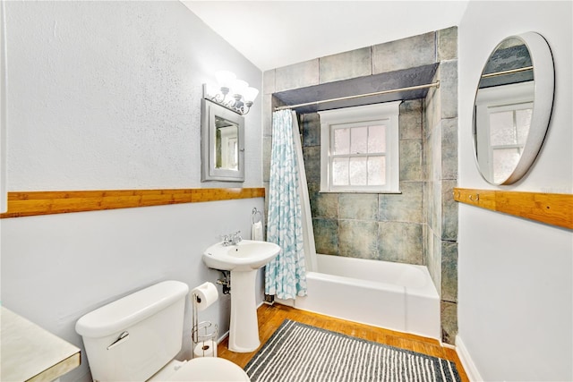 bathroom with a sink, shower / bath combo, wood finished floors, and toilet