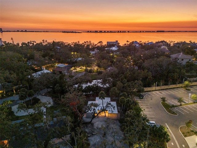 aerial view at dusk featuring a water view