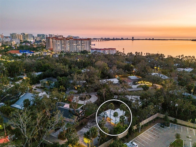 aerial view at dusk featuring a water view