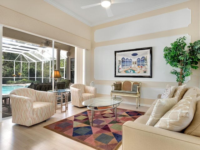 living room with hardwood / wood-style flooring, ceiling fan, and crown molding