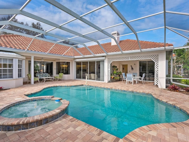 view of pool with a lanai, an in ground hot tub, and a patio