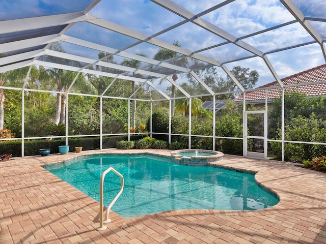 view of pool featuring an in ground hot tub, glass enclosure, and a patio area