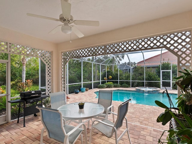 view of pool featuring glass enclosure, ceiling fan, an in ground hot tub, area for grilling, and a patio area