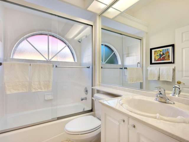 full bathroom featuring shower / bath combination with glass door, vanity, and toilet