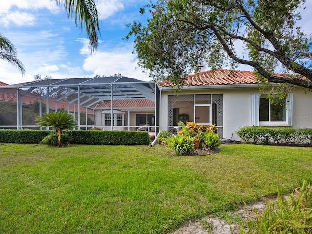 rear view of property with a yard and a lanai