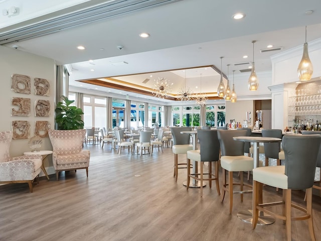 dining space with a tray ceiling, crown molding, plenty of natural light, and hardwood / wood-style flooring