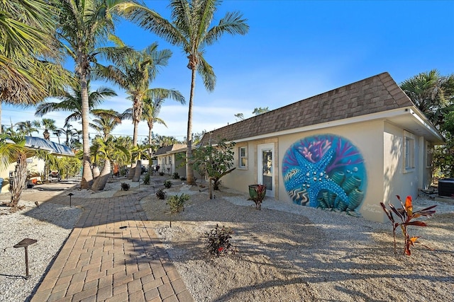 view of front facade with a patio and central AC unit