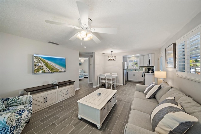 1123 Crescent St Unit 1123/1125, Sarasota, FL 34242 - living area with a ceiling fan, healthy amount of natural light, dark wood-type flooring, baseboards, and a textured ceiling